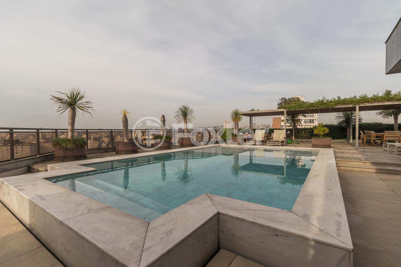 Piscina com deck e palmeiras